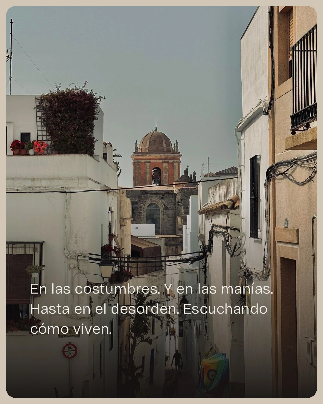 Munya Studio · Una iglesia aparece al fondo de una calle de edificios blancos.