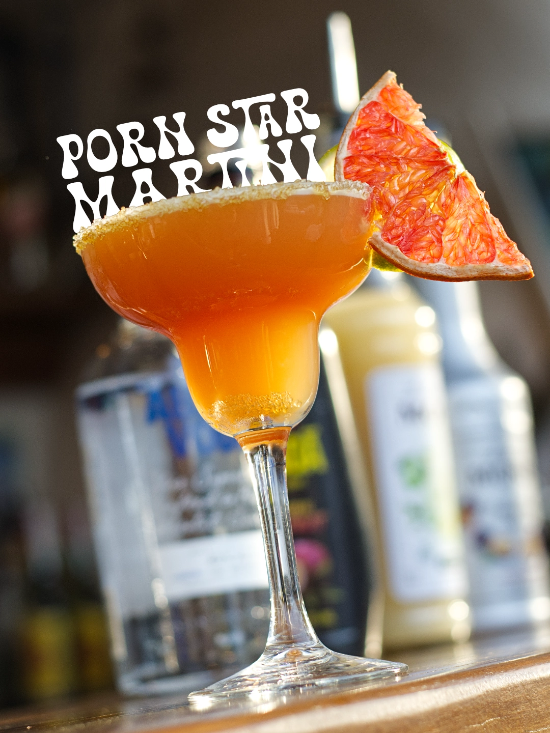 Fotografía de Porn Star Martini de Zaraho con naranja deshidratada y la tipografía blanca original.